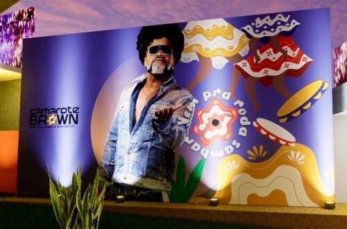 Arte visual do Camarote Brown 2026 com ilustração de Carlinhos Brown, elementos do samba de roda e texturas naturais que compõem a decoração do espaço no Circuito Dodô.