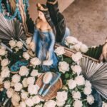 Escultura de Iemanjá decorada com flores brancas e azuis para celebração no Blue Praia Bar.