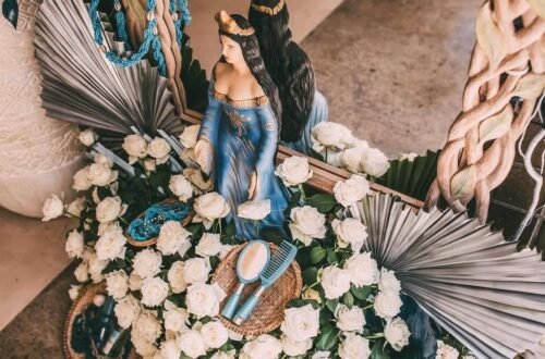 Escultura de Iemanjá decorada com flores brancas e azuis para celebração no Blue Praia Bar.