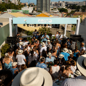 Vista aérea do rooftop do Canto Hotel com público acompanhando show ao vivo durante a festa de Iemanjá.