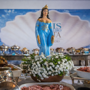 Imagem de Iemanjá adornada com flores brancas em destaque no Restaurante Amado para o evento "Dois de Fevereiro A Festa by Licia Fabio".