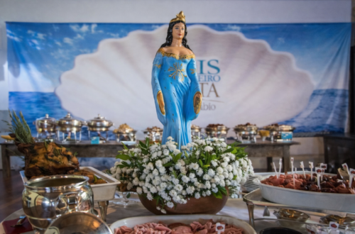 Imagem de Iemanjá adornada com flores brancas em destaque no Restaurante Amado para o evento "Dois de Fevereiro A Festa by Licia Fabio".
