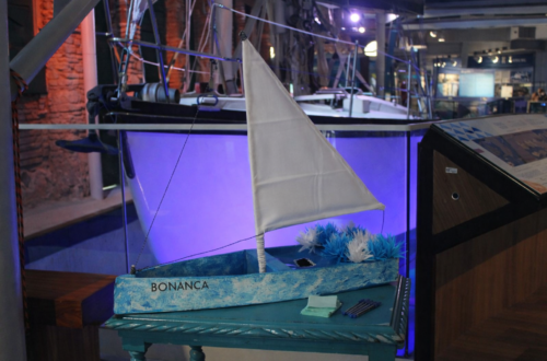 Miniatura do barco Bonança em tons de azul e branco, decorado com flores, para a ação de Iemanjá no Museu do Mar Aleixo Belov.