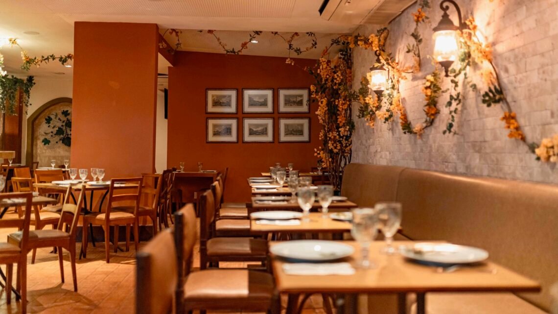 Interior do restaurante Di Liana com decoração aconchegante e iluminação quente.