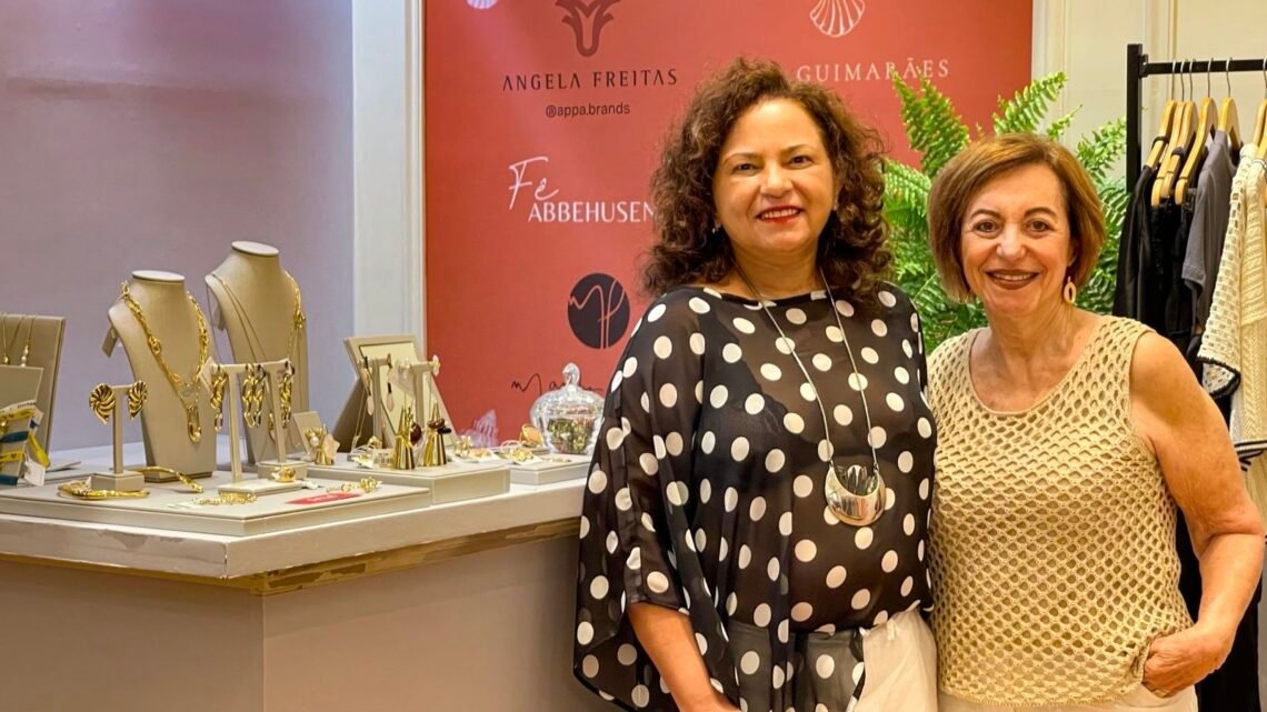 Nyscia Pinheiro e Regina Weckerle sorridentes posando para foto dentro da loja Casa da Estação no Shopping Barra.