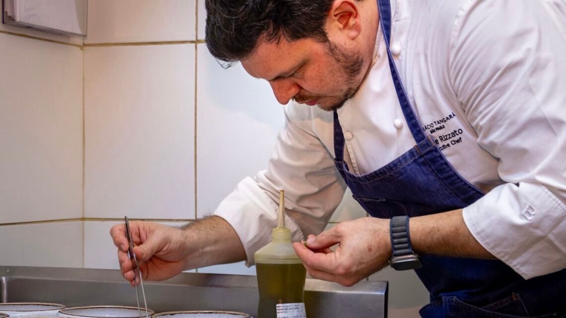 Chef Filipe Rizzato prepara prato na cozinha durante jantar especial de 20 anos do Restaurante Amado em Salvador.