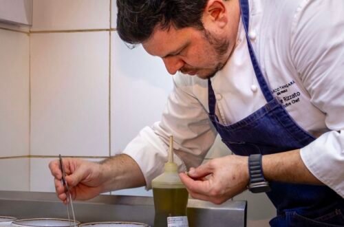 Chef Filipe Rizzato prepara prato na cozinha durante jantar especial de 20 anos do Restaurante Amado em Salvador.