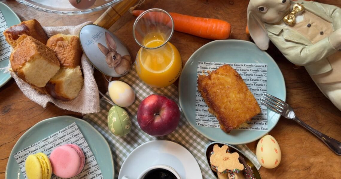 Café da manhã de Páscoa no Casarìa em Salvador com mesa posta, bolo, café, suco de laranja, macarons e decoração temática com coelho e ovos