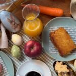 Café da manhã de Páscoa no Casarìa em Salvador com mesa posta, bolo, café, suco de laranja, macarons e decoração temática com coelho e ovos