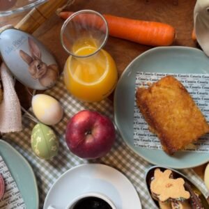 Café da manhã de Páscoa no Casarìa em Salvador com mesa posta, bolo, café, suco de laranja, macarons e decoração temática com coelho e ovos