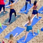 Aula de yoga ao amanhecer no Blue Praia com participantes na areia da Praia do Buracão em Salvador