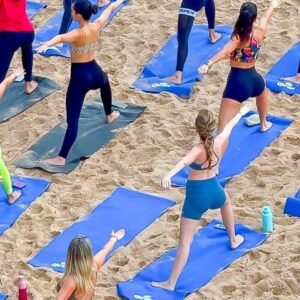 Aula de yoga ao amanhecer no Blue Praia com participantes na areia da Praia do Buracão em Salvador