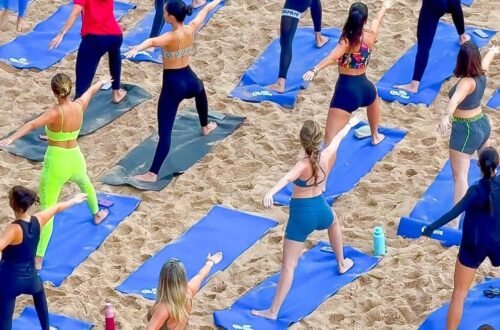 Aula de yoga ao amanhecer no Blue Praia com participantes na areia da Praia do Buracão em Salvador