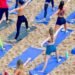 Aula de yoga ao amanhecer no Blue Praia com participantes na areia da Praia do Buracão em Salvador