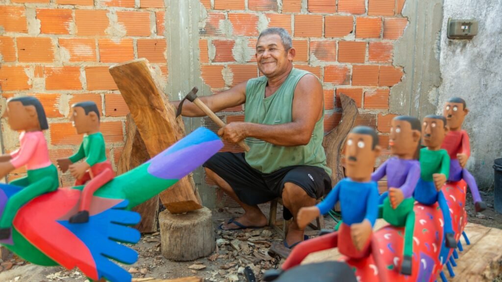 Artesão de Alagoas esculpindo madeira com ferramentas tradicionais para produção artesanal.