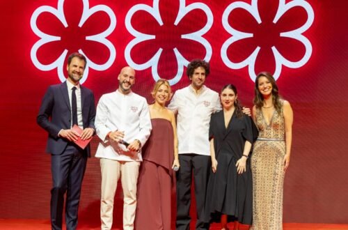 Cerimônia do Guia Michelin Brasil 2026 com chefs premiados e representantes no palco diante do símbolo das três estrelas