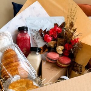 Cesta de brunch da Jeanne Garcia para o Dia das Mães com croissant, macarons, cafés especiais e flores.
