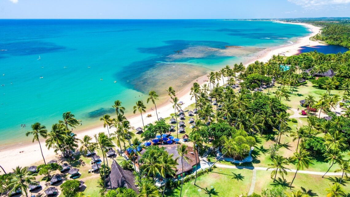 Vista aérea do Tivoli Ecoresort Praia do Forte, na Bahia, com coqueirais, faixa de areia e mar azul-turquesa. O resort está localizado à beira-mar e integra a paisagem natural da Praia do Forte.