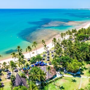 Vista aérea do Tivoli Ecoresort Praia do Forte, na Bahia, com coqueirais, faixa de areia e mar azul-turquesa. O resort está localizado à beira-mar e integra a paisagem natural da Praia do Forte.