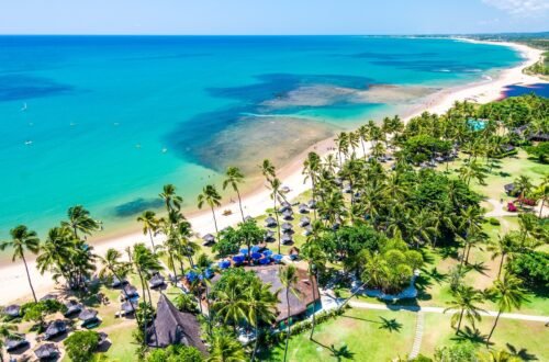 Vista aérea do Tivoli Ecoresort Praia do Forte, na Bahia, com coqueirais, faixa de areia e mar azul-turquesa. O resort está localizado à beira-mar e integra a paisagem natural da Praia do Forte.