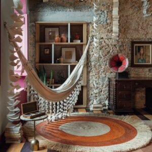 Ambiente da Casacor Bahia 2026 na Casa Nossa Senhora das Mercês, em Salvador, com rede, livros suspensos e elementos que valorizam arte, arquitetura e patrimônio histórico.