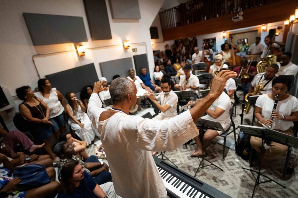 Maestro Ubiratan Marques rege a Orquestra Afrosinfônica na Igreja do Rosário dos Pretos durante apresentação com músicos e público em Salvador.