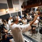 Maestro Ubiratan Marques rege a Orquestra Afrosinfônica na Igreja do Rosário dos Pretos durante apresentação com músicos e público em Salvador.