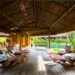 Área de descanso do Anantara Spa, com espreguiçadeiras de madeira sob cobertura de palha e jardins ao redor.