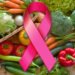 Laço rosa sobre legumes e verduras ilustra o tema alimentação e câncer de mama.